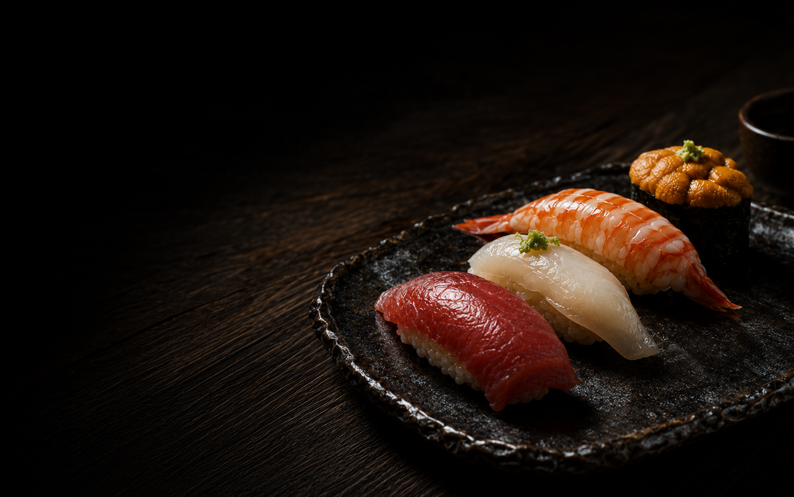 An assortment of premium Edo-style nigiri on black ceramic